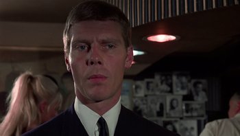 Movie still from “Performance” (1970), directed by Donald Cammell – A person wearing a suit and tie; Close Up shot, Low angle