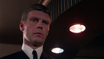 Movie still from “Performance” (1970), directed by Donald Cammell – A person wearing a suit and tie; Close Up shot, Low angle