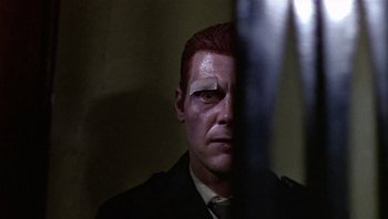 Movie still from “Performance” (1970), directed by Donald Cammell – A person wearing a suit and tie; Close Up shot, Low angle