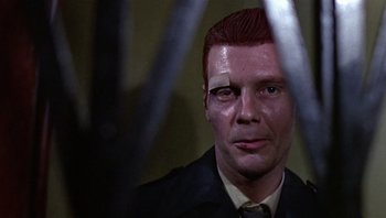 Movie still from “Performance” (1970), directed by Donald Cammell – A person wearing a suit and tie; Close Up shot, Low angle