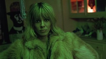 Movie still from “Performance” (1970), directed by Donald Cammell – A woman in a green fur coat looking at the camera; Close Up shot, Low angle