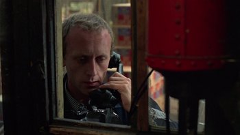 Movie still from “Performance” (1970), directed by Donald Cammell – A man talking on a phone while looking out a window; Close Up shot, Low angle