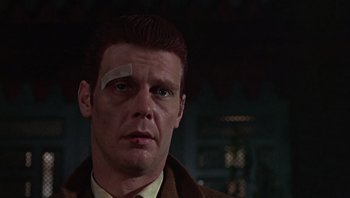 Movie still from “Performance” (1970), directed by Donald Cammell – A person with a bandage on his face; Close Up shot, Low angle