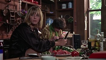 Movie still from “Performance” (1970), directed by Donald Cammell – Two women cutting vegetables at a table in a kitchen; Medium shot, Low angle