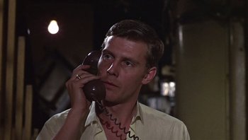 Movie still from “Performance” (1970), directed by Donald Cammell – A man holding a phone up to his ear; Close Up shot, Low angle