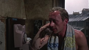 Movie still from “Performance” (1970), directed by Donald Cammell – A man is talking on a phone in a room; Close Up shot, High angle