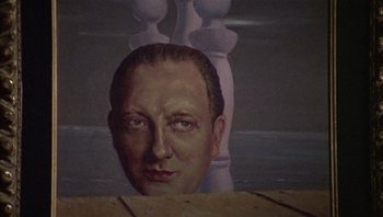 Movie still from “Performance” (1970), directed by Donald Cammell – A painting of a man's head with a chess piece in the background; Close Up shot, Low angle