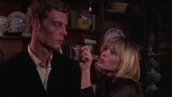 Movie still from “Performance” (1970), directed by Donald Cammell – A man and a woman are smoking a cigarette together; Close Up shot, Low angle