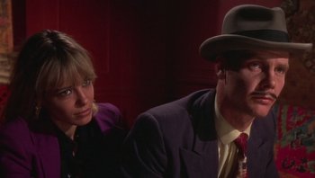 Movie still from “Performance” (1970), directed by Donald Cammell – A man and a woman sitting next to each other; Close Up shot, High angle