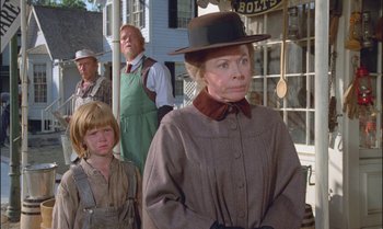 Movie still from “Pete's Dragon” (1977), directed by Don Chaffey – An older woman and two young boys in a town; Medium shot, Over the shoulder angle