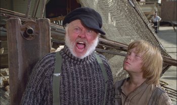 Movie still from “Pete's Dragon” (1977), directed by Don Chaffey – An old man and a young boy are standing next to each other; Medium shot, Low angle