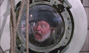 Movie still from “Pete's Dragon” (1977), directed by Don Chaffey – An old man with a beard wearing a black hat; Close Up shot, Overhead angle