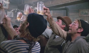 Movie still from “Pete's Dragon” (1977), directed by Don Chaffey – A group of people raising their glasses in the air at an event; Medium shot, Low angle