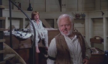 Movie still from “Pete's Dragon” (1977), directed by Don Chaffey – An old man and a young girl in a room; Medium shot, Low angle