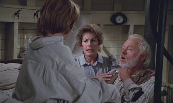 Movie still from “Pete's Dragon” (1977), directed by Don Chaffey – A group of people standing next to each other in a room; Medium shot, Over the shoulder angle