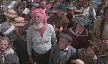 Movie still from “Pete's Dragon” (1977), directed by Don Chaffey – A group of people that are standing up together; Medium shot, High angle