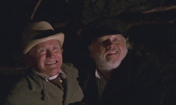 Movie still from “Pete's Dragon” (1977), directed by Don Chaffey – Two older men sitting next to each other in a dark room; Close Up shot, Low angle