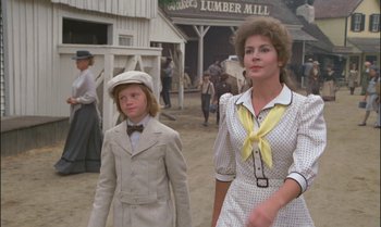 Movie still from “Pete's Dragon” (1977), directed by Don Chaffey – A woman and a boy are walking in the dirt; Medium shot, Over the shoulder angle