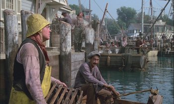 Movie still from “Pete's Dragon” (1977), directed by Don Chaffey – A group of people sitting in a boat on a body of water; Wide shot, High angle