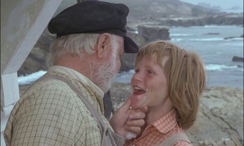 Movie still from “Pete's Dragon” (1977), directed by Don Chaffey – An older man and a young girl are smiling; Close Up shot, Over the shoulder angle