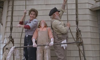 Movie still from “Pete's Dragon” (1977), directed by Don Chaffey – A group of people standing next to each other on a pole; Medium shot, Low angle