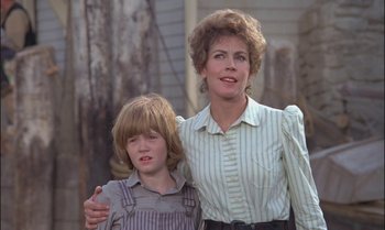 Movie still from “Pete's Dragon” (1977), directed by Don Chaffey – A woman and a boy standing next to each other; Medium shot, Over the shoulder angle