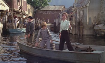 Movie still from “Pete's Dragon” (1977), directed by Don Chaffey – A woman and two boys are in a boat in the water; Wide shot, High angle