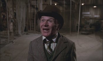 Movie still from “Pete's Dragon” (1977), directed by Don Chaffey – An older man wearing a hat and a suit; Medium shot, Low angle