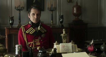 Movie still from “Peterloo” (2018), directed by Mike Leigh – A man sitting at a table in a room; Medium shot, Over the shoulder angle