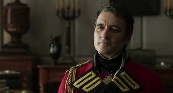Movie still from “Peterloo” (2018), directed by Mike Leigh – A man in a red and black uniform looking to his left; Close Up shot, Over the shoulder angle