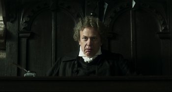 Movie still from “Peterloo” (2018), directed by Mike Leigh – An older man in a black robe looking at the camera; Medium shot, Low angle
