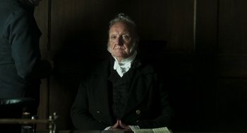 Movie still from “Peterloo” (2018), directed by Mike Leigh – An older man sitting at a table in front of a book; Close Up shot, Low angle