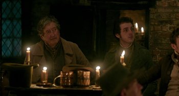 Movie still from “Peterloo” (2018), directed by Mike Leigh – Two men sitting at a table with candles in front of them; Medium shot, Over the shoulder angle