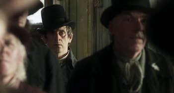 Movie still from “Peterloo” (2018), directed by Mike Leigh – A man wearing a top hat and a coat; Close Up shot, Over the shoulder angle