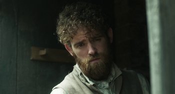 Movie still from “Peterloo” (2018), directed by Mike Leigh – A man with curly hair and a beard wearing a vest; Close Up shot, Low angle