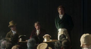Movie still from “Peterloo” (2018), directed by Mike Leigh – Two men are standing in front of an audience; Medium shot, Over the shoulder angle
