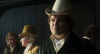Movie still from “Peterloo” (2018), directed by Mike Leigh – A man wearing a cowboy hat in front of another man; Close Up shot, Over the shoulder angle