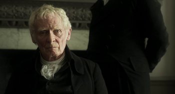 Movie still from “Peterloo” (2018), directed by Mike Leigh – An older man in a black coat and white shirt; Close Up shot, Over the shoulder angle