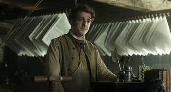 Movie still from “Peterloo” (2018), directed by Mike Leigh – A man standing in front of a table with a pen and a quill; Medium shot, Low angle