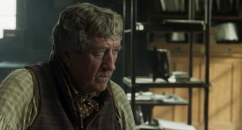 Movie still from “Peterloo” (2018), directed by Mike Leigh – An older man sitting in front of a bookshelf; Close Up shot, Over the shoulder angle