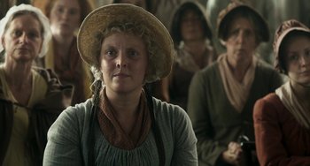 Movie still from “Peterloo” (2018), directed by Mike Leigh – A woman in a hat and a group of other women; Close Up shot, Over the shoulder angle