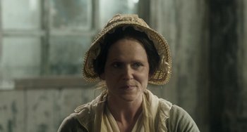 Movie still from “Peterloo” (2018), directed by Mike Leigh – A woman wearing a straw hat and a scarf; Close Up shot, High angle