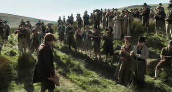 Movie still from “Peterloo” (2018), directed by Mike Leigh – A group of people standing in a grassy field; Wide shot, High angle