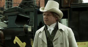 Movie still from “Peterloo” (2018), directed by Mike Leigh – A man wearing a white hat and a long coat; Close Up shot, Over the shoulder angle