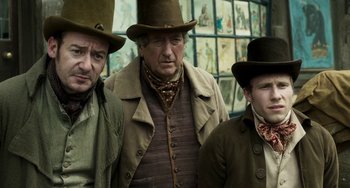 Movie still from “Peterloo” (2018), directed by Mike Leigh – A group of men standing next to each other wearing hats; Medium shot, Low angle