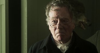 Movie still from “Peterloo” (2018), directed by Mike Leigh – An older man with a beard and glasses; Close Up shot, Over the shoulder angle