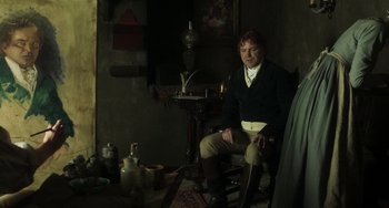 Movie still from “Peterloo” (2018), directed by Mike Leigh – A man sitting on a chair in a room; Medium shot, Over the shoulder angle