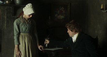 Movie still from “Peterloo” (2018), directed by Mike Leigh – A woman and a young man are writing on a paper; Medium shot, High angle