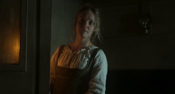 Movie still from “Peterloo” (2018), directed by Mike Leigh – A woman standing in a room with a dark background; Medium shot, Low angle
