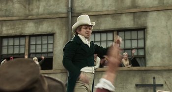 Movie still from “Peterloo” (2018), directed by Mike Leigh – A man wearing a white hat and a green jacket; Medium shot, Low angle